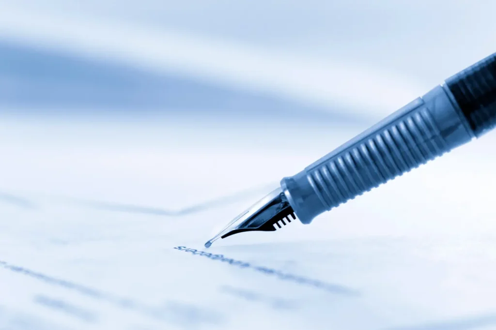 en la imagen se puede ver una pluma escribiendo